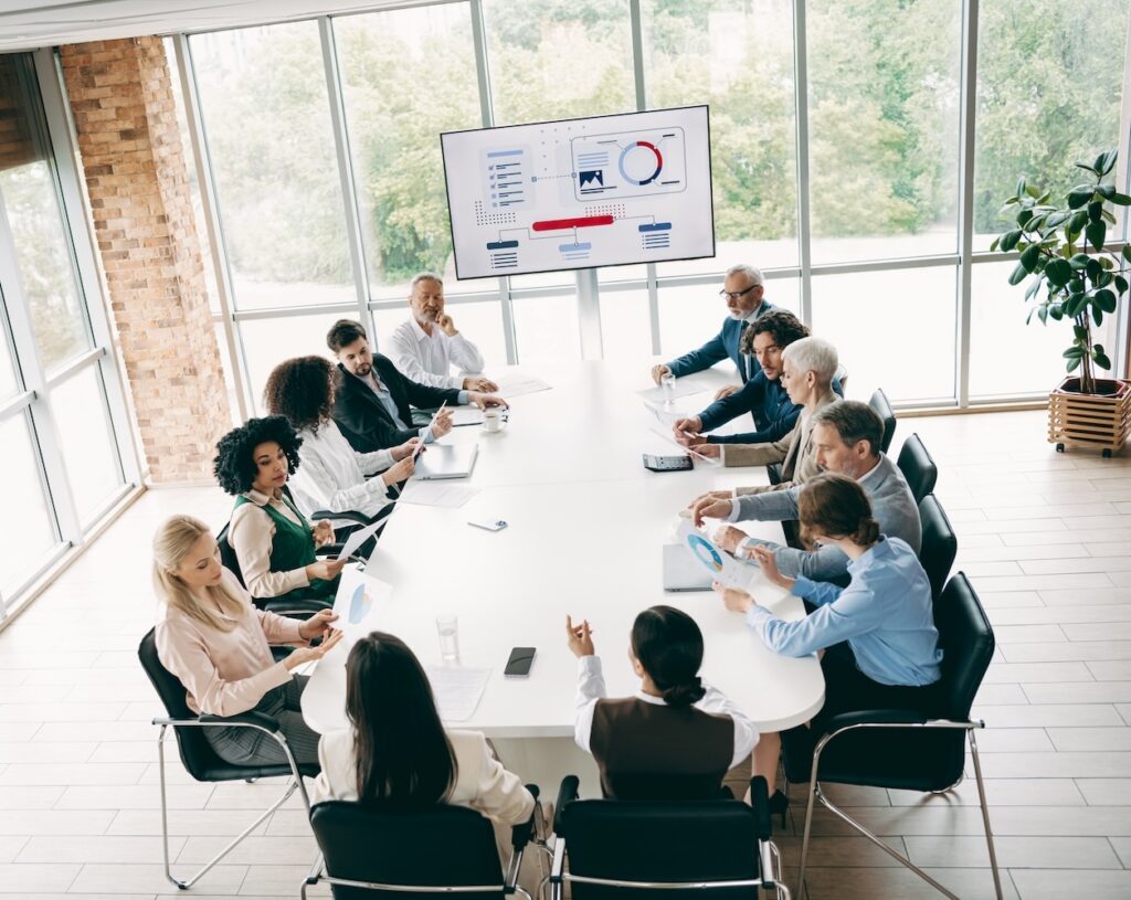 salesperson presenting to a boardroom of decision-makers