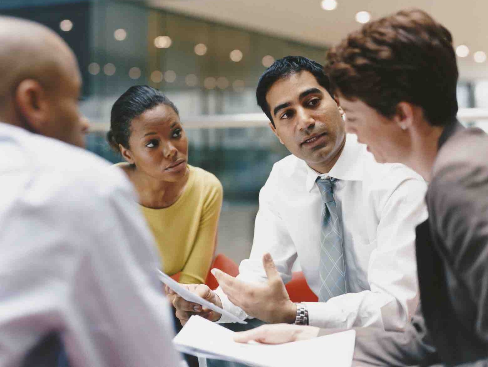 Business People Sitting in an Office Building Having a Meeting regarding insurance challenges in sales training.