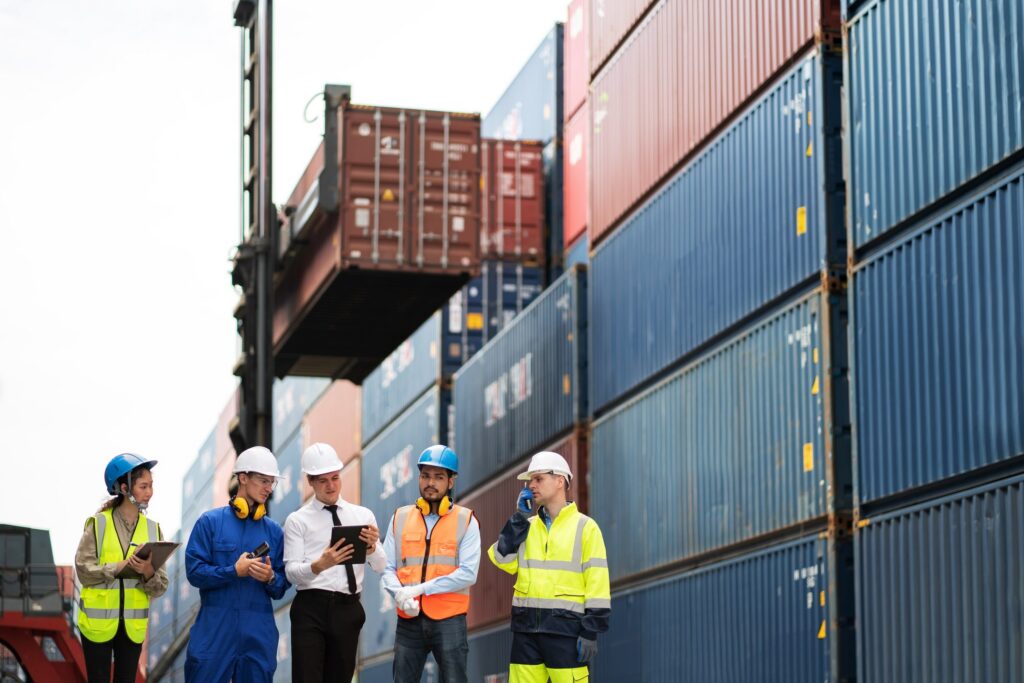 Transportation salespeople meeting with clients by shipping containers